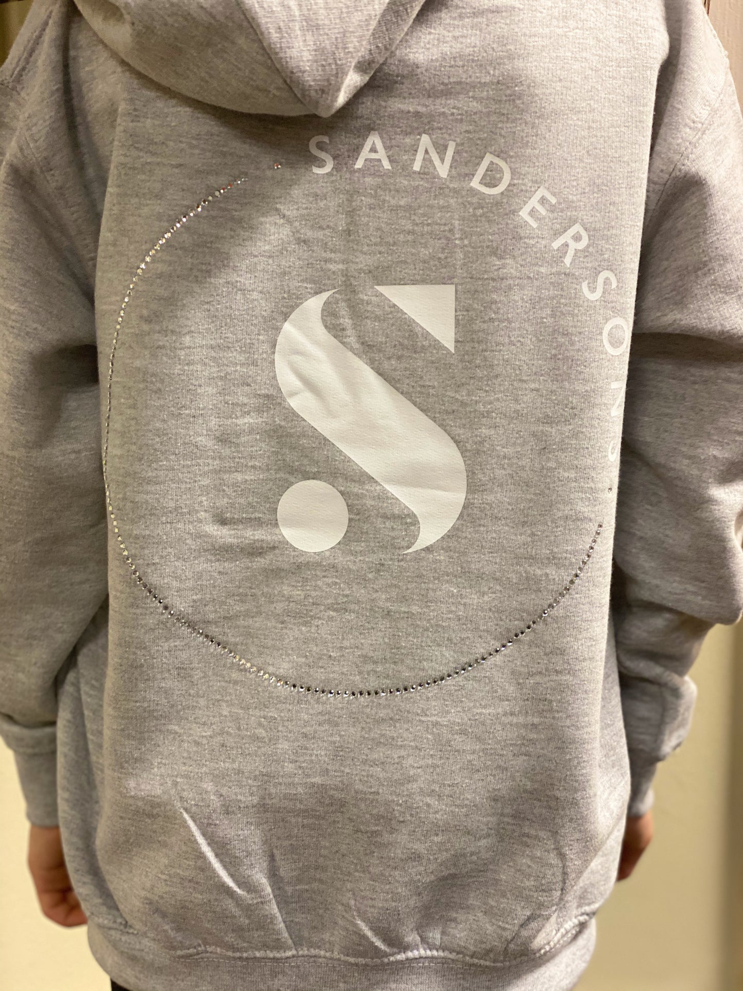 KIDS GREY SANDERSONS PULLOVER HOODIE BY AXZNT WITH WHITE BADGE PRINT AND LARGE WHITE/ SILVER PRINT & STONES