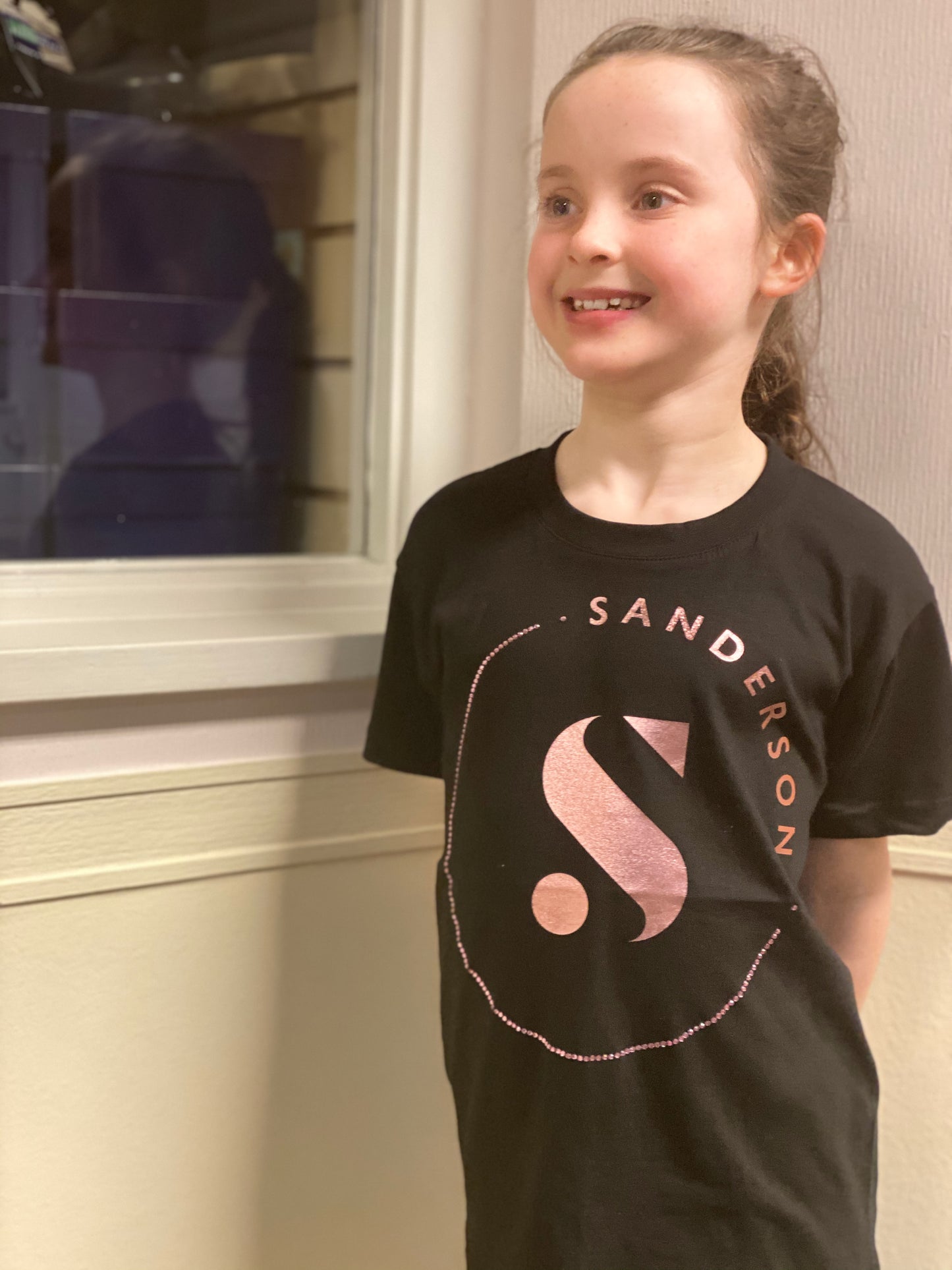 KIDS BLACK SANDERSONS T SHIRT BY AXZNT WITH LARGE ROSE GOLD PRINT & STONES